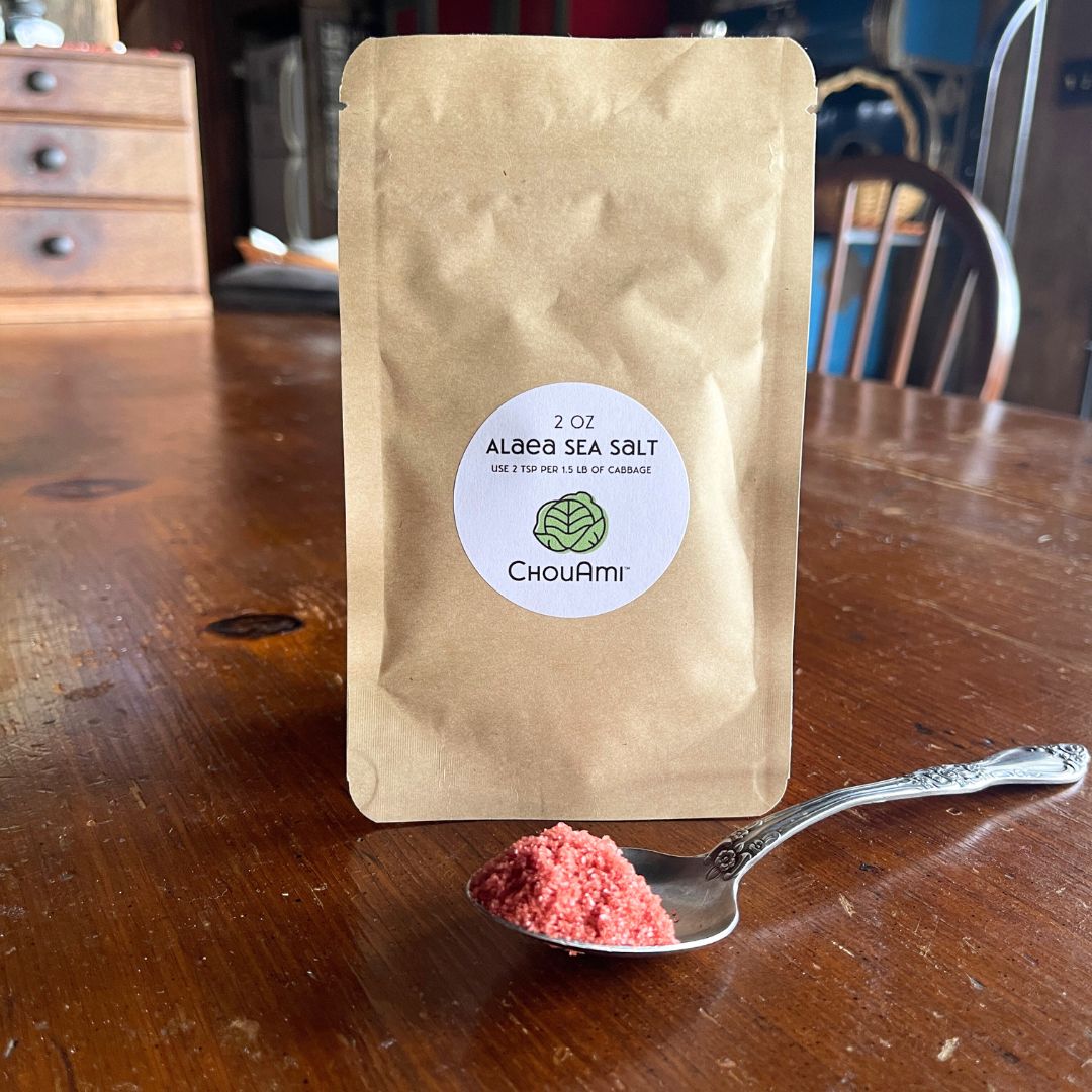 ChouAmi Alaea Sea Salt 2oz kraft pouch with a spoonful of red-hued sea salt on a wooden table.