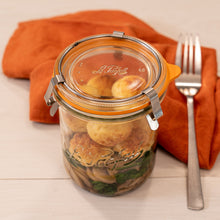 Load image into Gallery viewer, Le Parfait Bistrot Jar of pan-fried mushrooms, spinach, and golden fishcakes beside a fork and orange linen napkin.