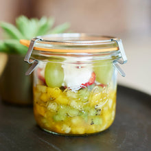 Load image into Gallery viewer, Le Parfait Bistrot Jar of layered fruit salad with grapes, kiwi, strawberry, and yogurt on a dark serving plate.