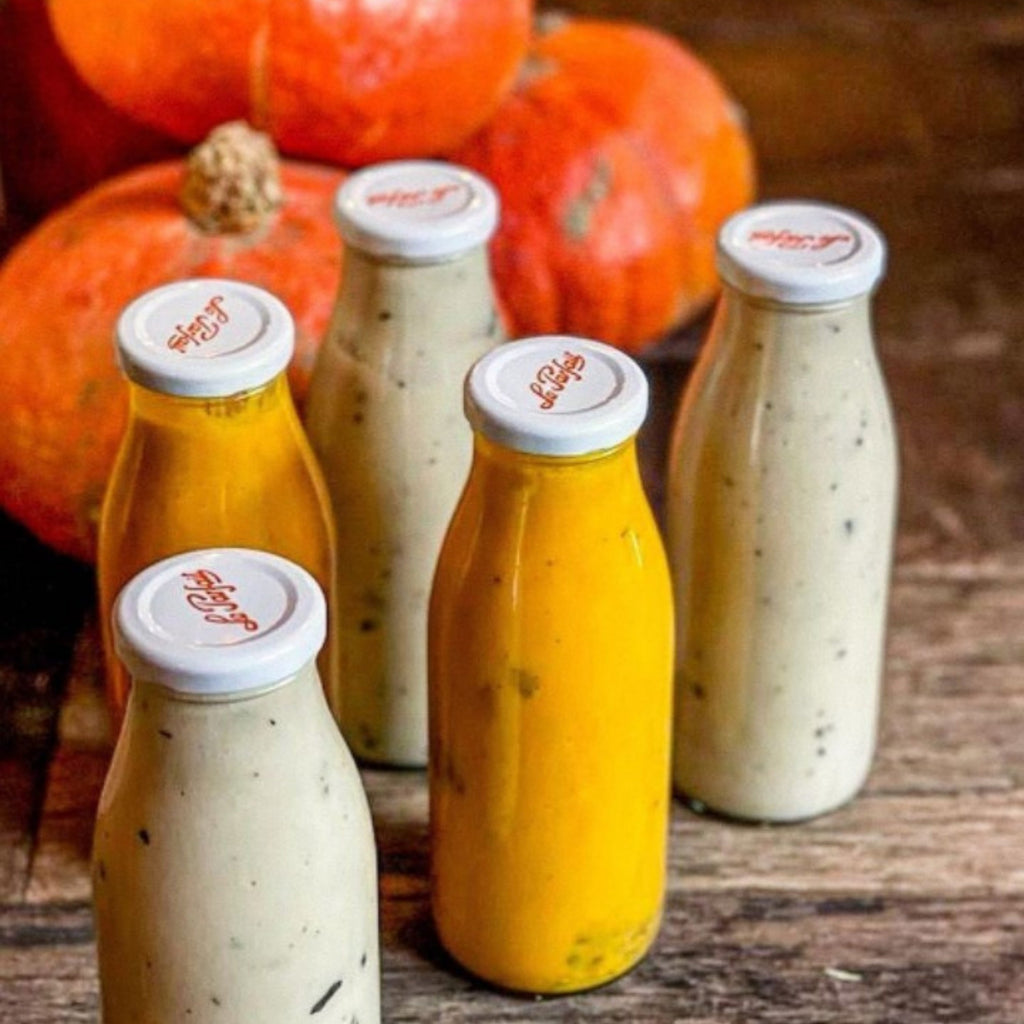 Freshly made homemade juices stored in clear swing top bottles.