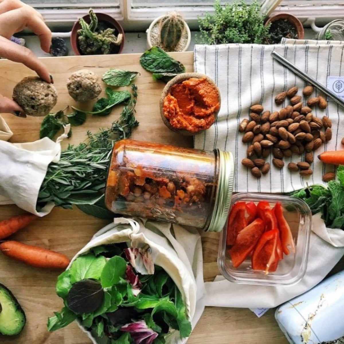 Top-down zero-waste lunch: Le Parfait Familia Wiss terrine of chickpea stew with almonds, vegetables, and greens on linen napkins.