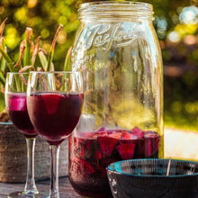 Load image into Gallery viewer, Le Parfait Screw Top Jar of fruit-infused red sangria with grapes and apples beside two filled wine glasses at an outdoor garden table.