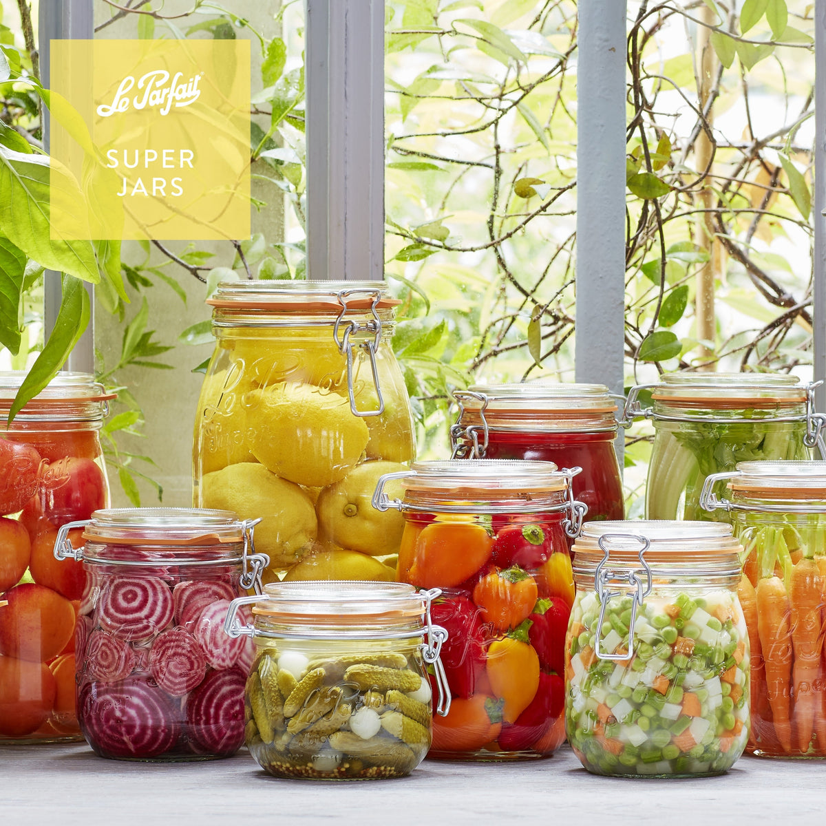 A kitchen counter with several clear wire bail canning jars.