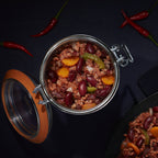 Top-down Le Parfait Super Terrine of chili con carne with red kidney beans, ground beef, peppers, and red chiles on a dark surface.