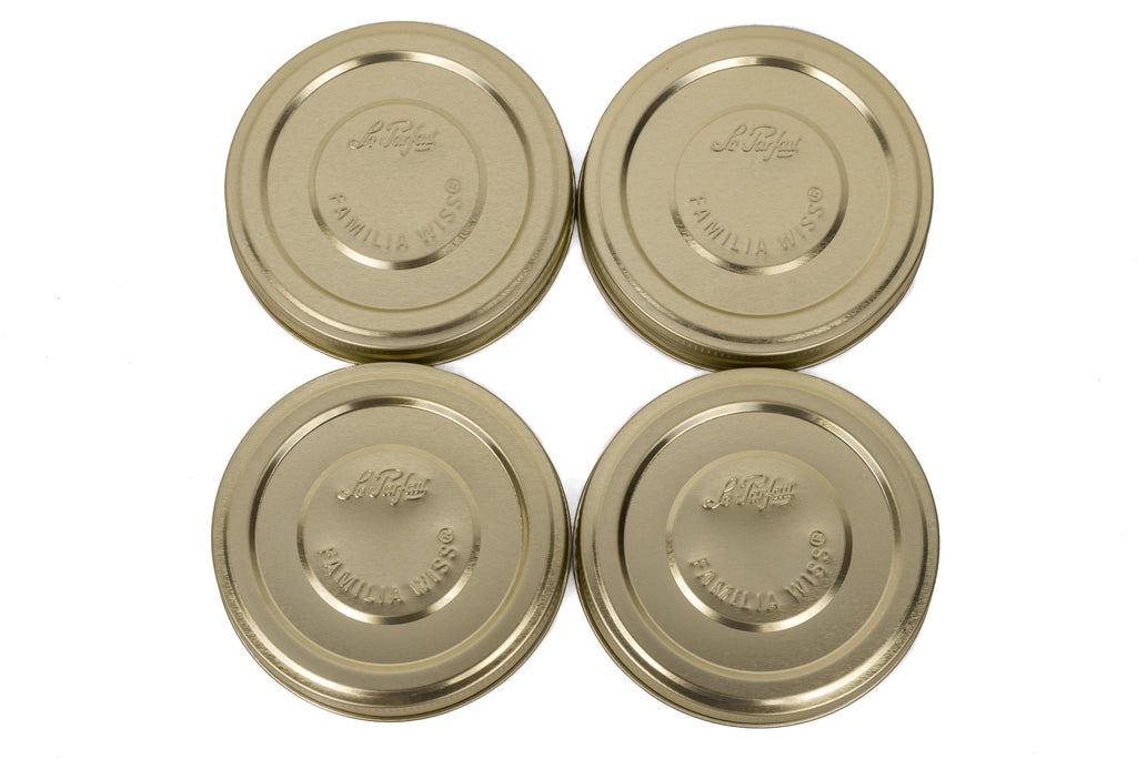 Four gold Le Parfait Familia Wiss metal screw lids in 110mm size, top-down on white.