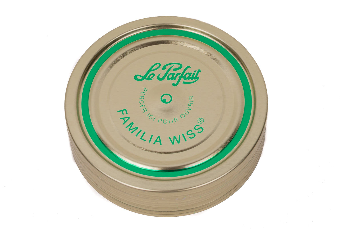 Top-down Le Parfait Familia Wiss sealing cap with green 'pierce-here' indicator and 'Le Parfait Familia Wiss' branding.