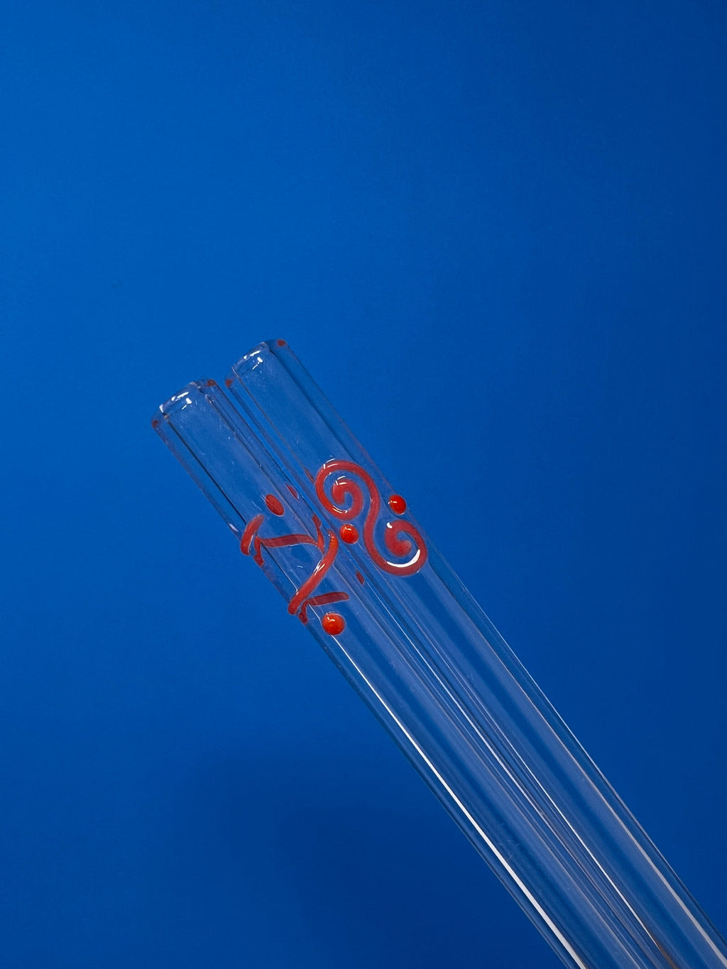 Three Le Parfait glass drinking straws bundled together with a red Celtic-spiral accent.