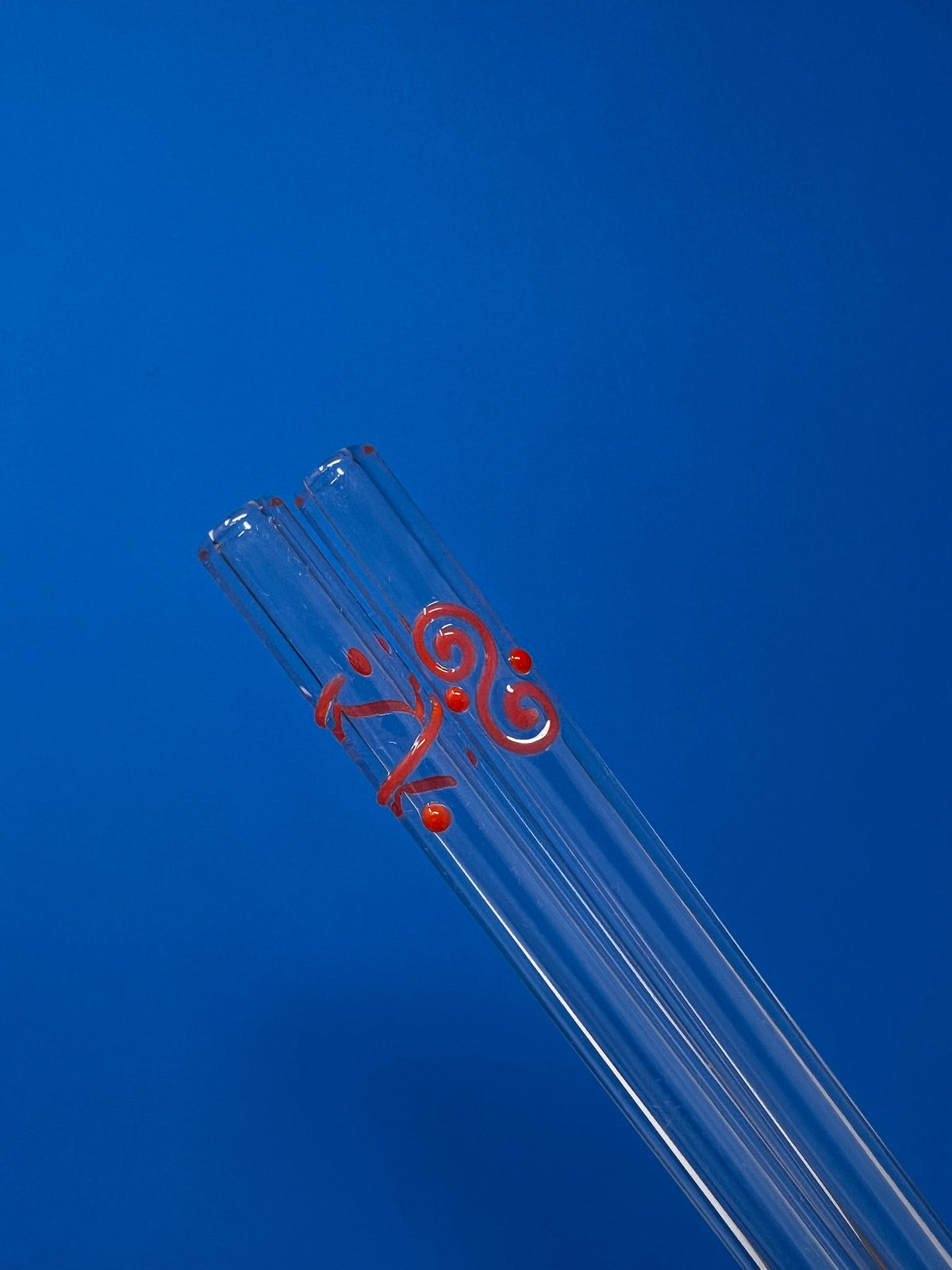 Three Le Parfait glass drinking straws bundled together with a red Celtic-spiral accent.