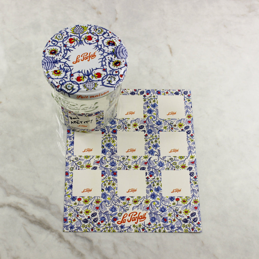 Le Parfait Labels Provençal blue floral sheet on marble beside a Bistrot jar with matching patterned lid and 'Fait Maison' branding.