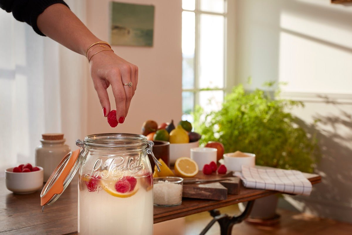 Adding raspberries to a Le Parfait Super Jar of homemade kefir